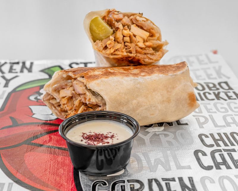 A FiL FiL chicken shawarma sandwich with garlic sauce