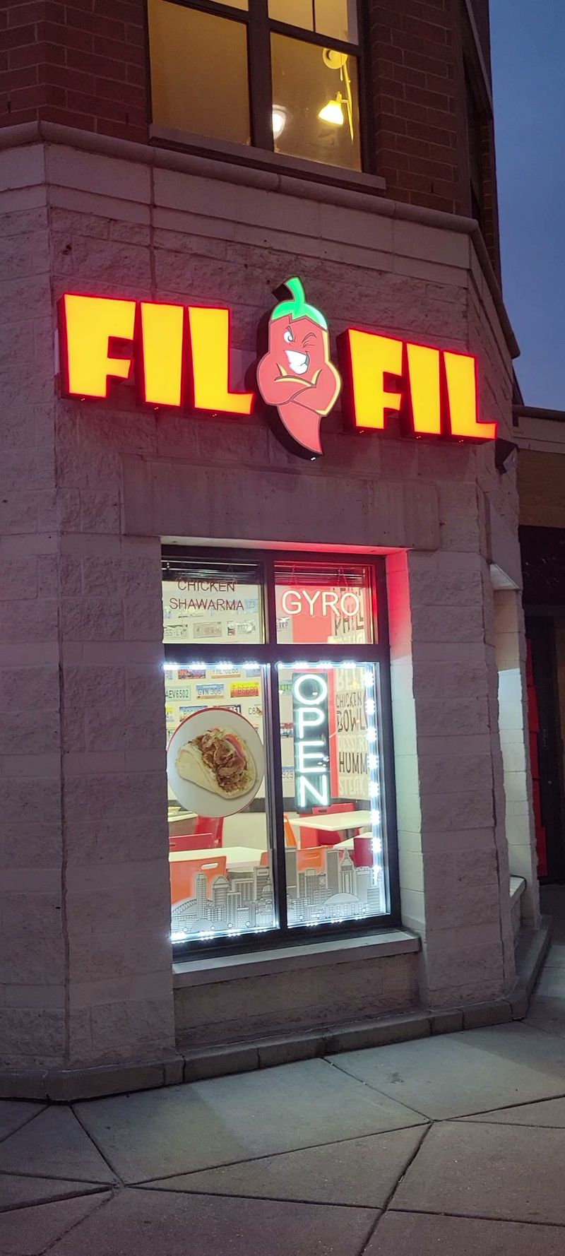 The lit FiL FiL storefront on Wisconsin Avenue at night